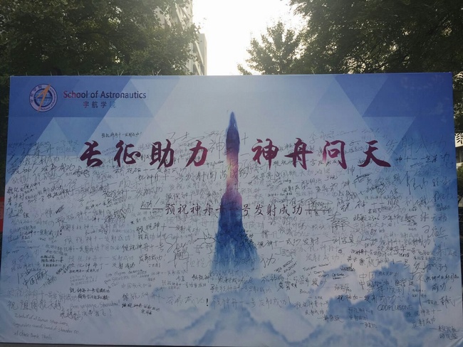 1476683306449240.jpg 我校多名同学在北航大学“长征助力 神舟问天”展板上签字.jpg